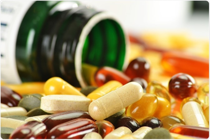 Composition with nutritional supplement capsules and containers. Image Credit: monticello / Shutterstock