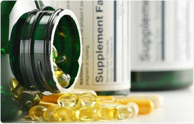 Composizione con le capsule ed i contenitori di supplemento dietetico. Varietà di pillole della droga - credito di immagine: monticello/Shutterstock