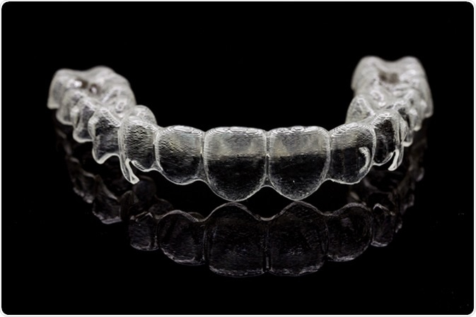 Invisalign braces or retainer isolated on black background. Image Credit: 1989studio / Shutterstock