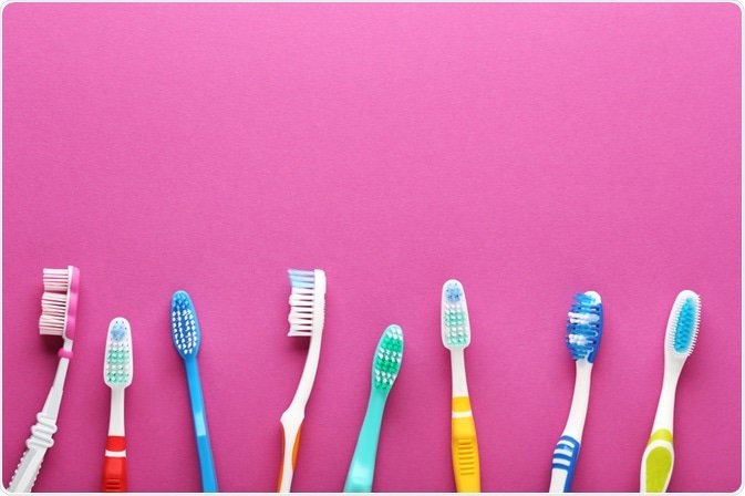 Picture of various types of toothbrushes in a line, on a pink background - picture taken by 5 second Studio