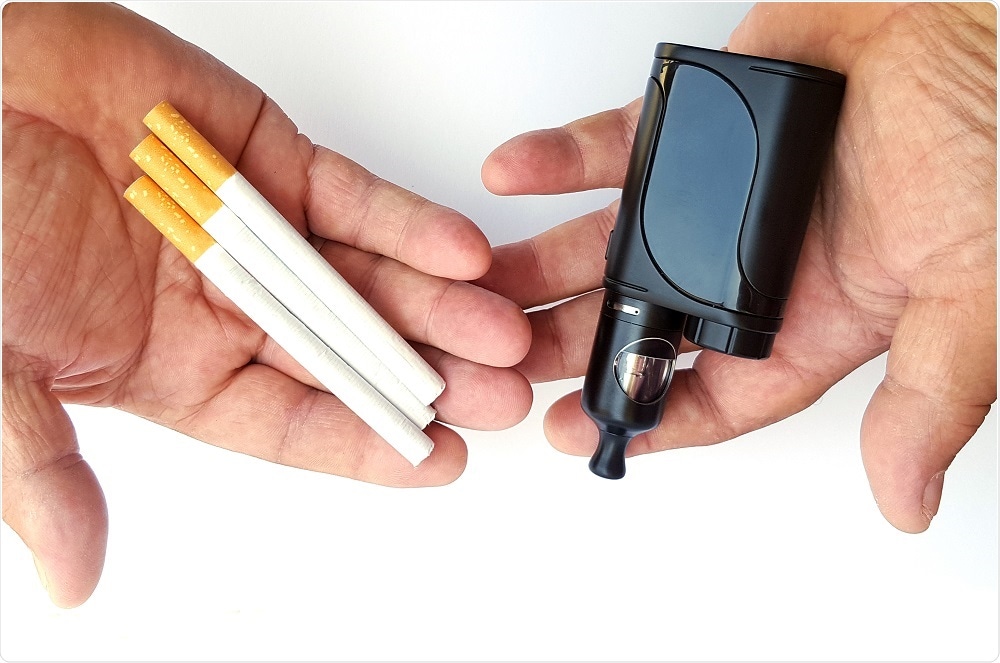 E-cigarettes versus cigarettes - both types of cigarette within the hands of smoker