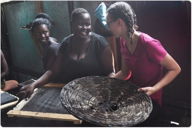 Senior Danielle Gleason (right) speaks with Goretti Ariago (center) and Salume Awiyo (left), employees of Appropriate Energy Saving Technologies, in Soroti, Uganda. Gleason has made two trips to Uganda to help streamline the production of charcoal briquettes which offer a low-smoke alternative for home cooking fuel. Photo: John Freidah