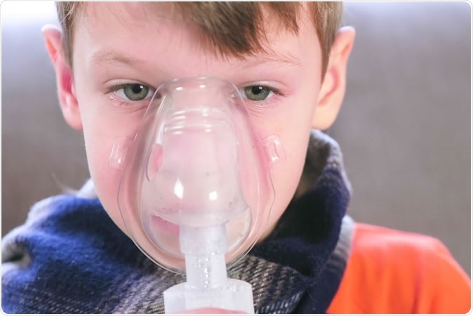 A child with asthma uses an inhaler. A new study from Washington University School of Medicine in St. Louis showed a correlation between the types of bacteria in the upper airway and severity of asthma symptoms. The study will lead to future research seeking possible ways to alter the airway microbiome to reduce asthma severity. Image Credit: Vadim Zakharishchev / Shutterstock