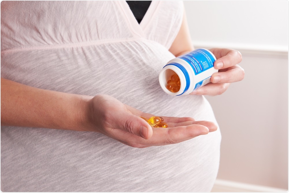 Pregnant woman taking prenatal supplements