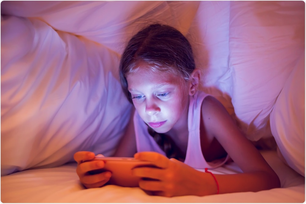 Child in bed on smartphone
