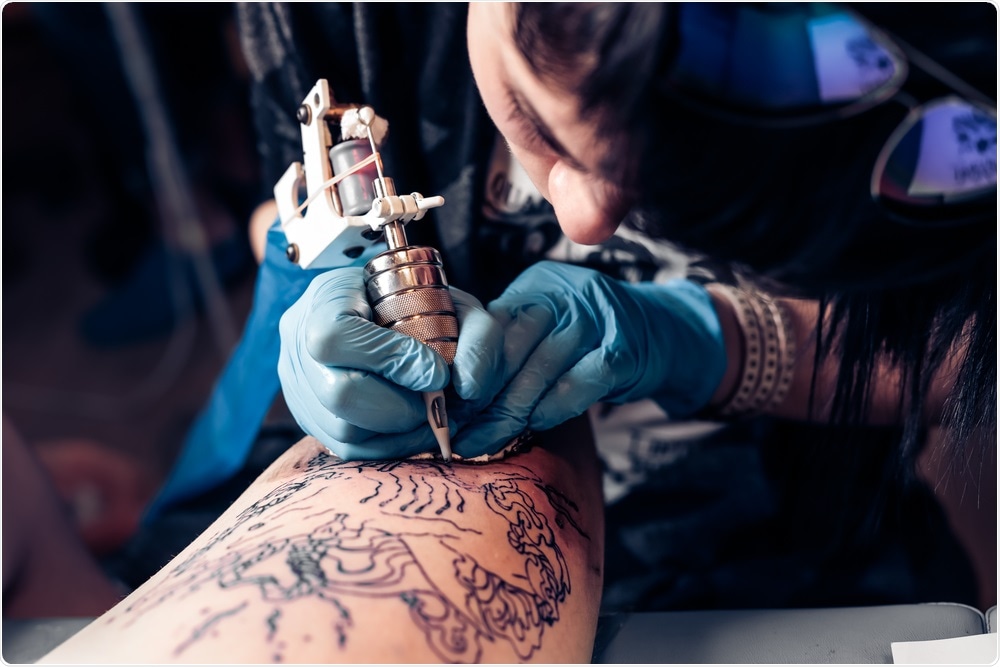 Tattoo artist giving a tattoo to a customer