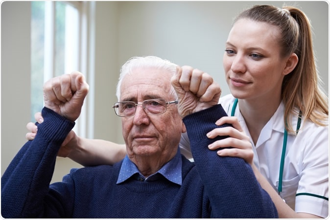 Nurse assessing stroke victim by raising arms. Image Credit: SpeedKingz / Shutter