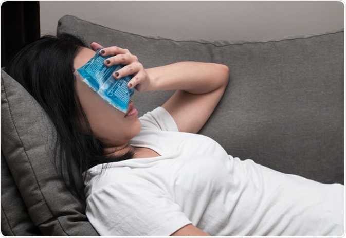 Woman with ice pack for migraine relief. Image Credit: Baranq / Shutterstock