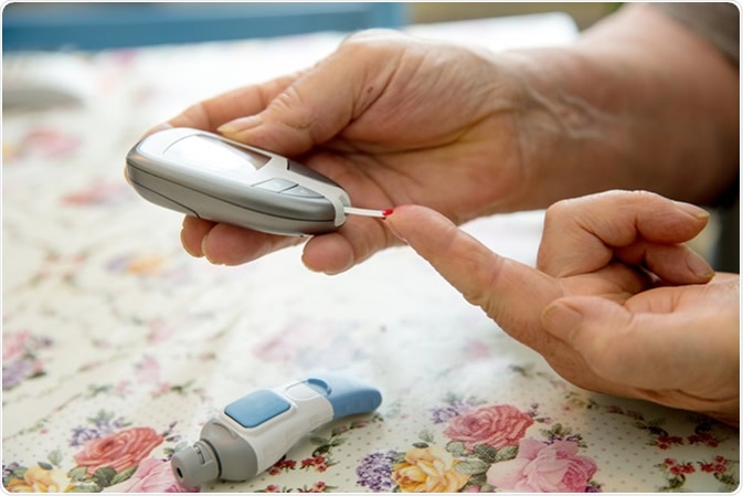 Diabetic checking sugar level with a glucometer. Image Credit: urbans / Shutterstock