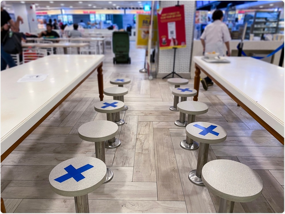 Singapore Mar 2020 Social distancing rules in practice, alternate seating in local public food courts. Image Credit: kandl stock / Shutterstock