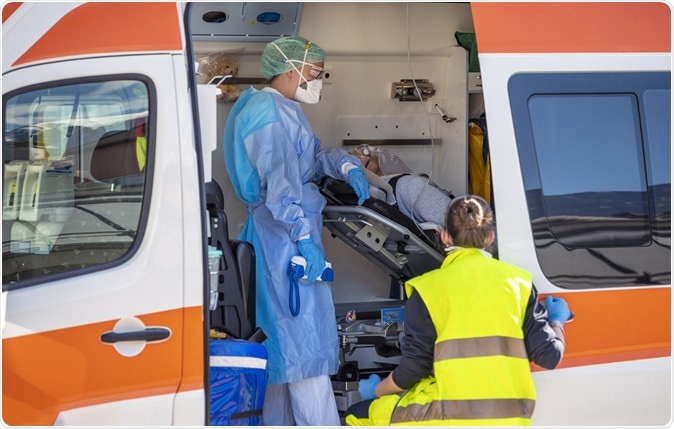 Covid-19. Italian paramedics with protective masks assist a man with Coronavirus Image Credit: faboi / Shutterstock