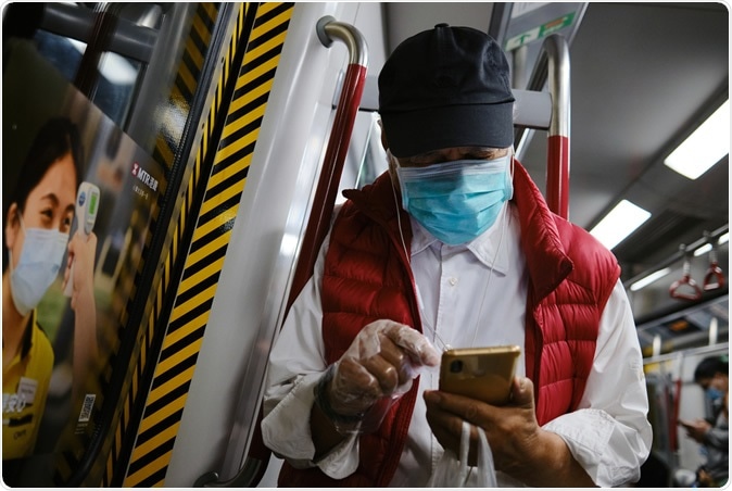 Hong Kong/ China- March 18, 2020: Passengers on a MTR underground metro train wear face masks and gloves as a precautionary measure against the COVID-19 coronavirus. Image Credit: Isaac C.P. Wong / Shutterstock
