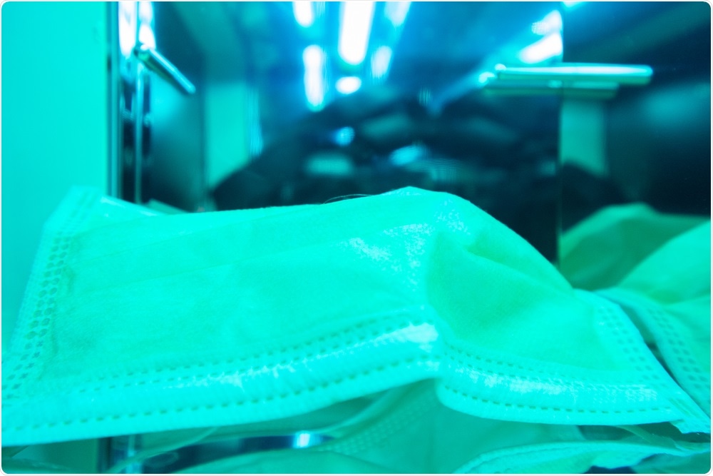 Surgical mask is irradiated by UVC (ultraviolet C) light. Image Credit: SMPTY 17 photography mos / Shutterstock