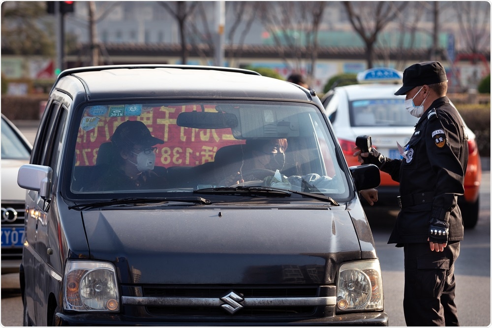 A Policeman checking temperature during the COVID-19 outbreak in China (BEIJING). Image Credit: Openfinal / Shutterstock