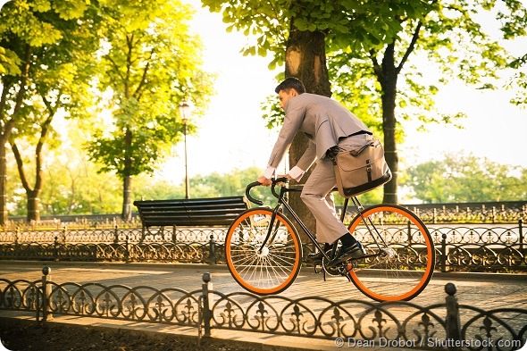 Businessman riding bicycle to work in park
