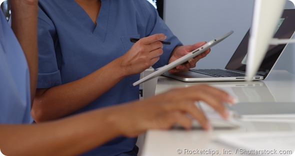 Close up hands of two female doctors working with computers