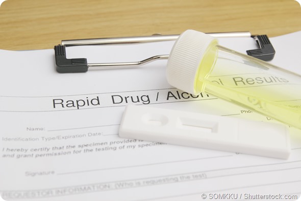 Drug test blank form with test kit and urine, focus on paper