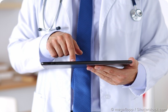 Male doctor holding digital tablet pc and pointing it with finger. Medical equipment, modern technology and communication concept