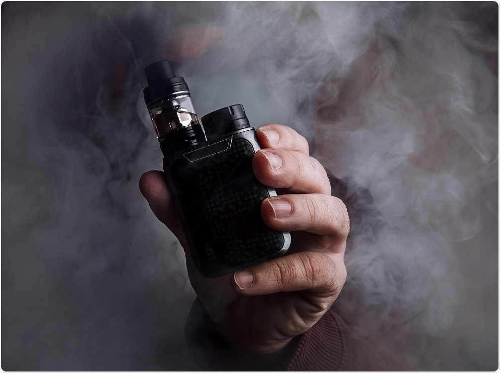 Person smoking e-cigarette with vapor in the air