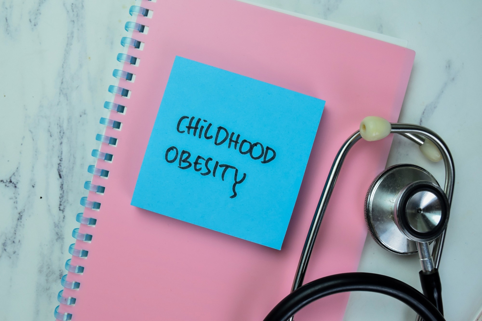 Notizbuch mit Haftnotiz mit der Aufschrift „Fettleibigkeit bei Kindern“.